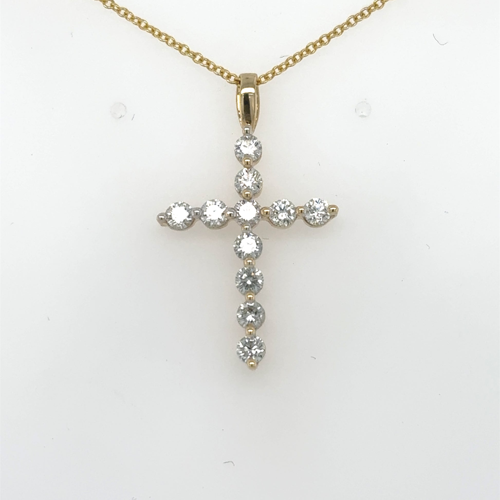 14K yellow gold cross pendant with round diamonds in shared prong settings.