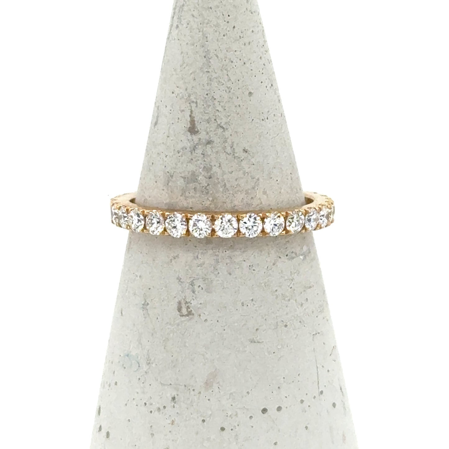 18K yellow gold eternity band with round brilliant diamonds in four-prong settings.