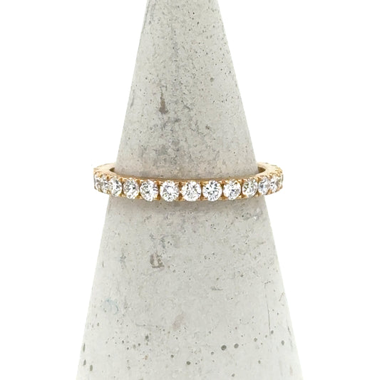18K yellow gold eternity band with round brilliant diamonds in four-prong settings.