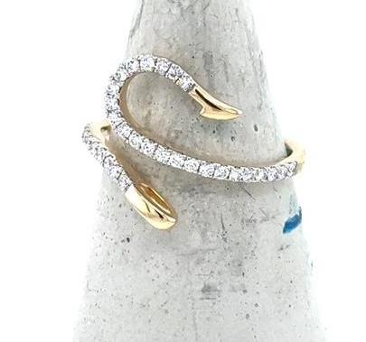 14K yellow gold fish hook ring with pavé round diamonds on an open band.