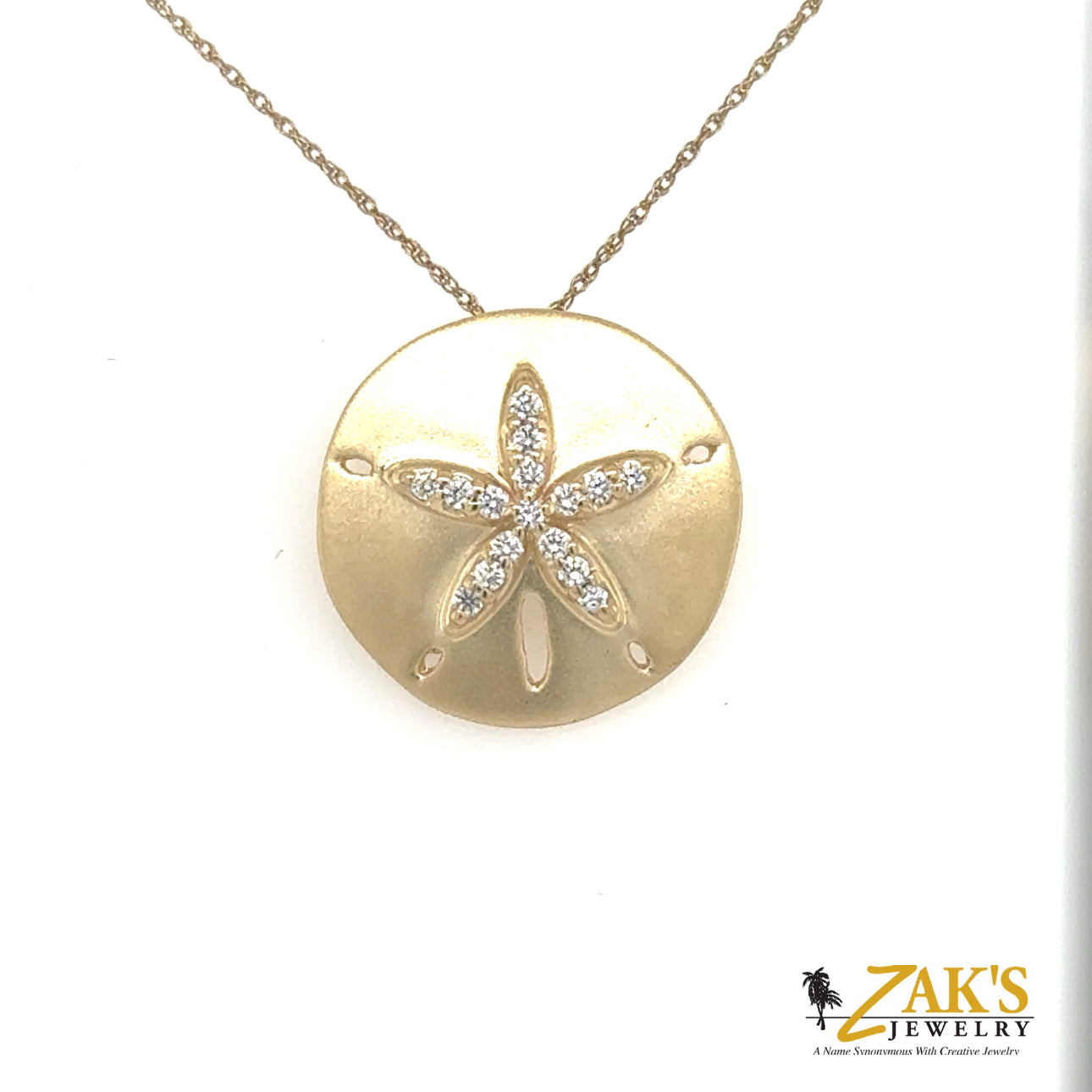 14K yellow gold sand dollar pendant with diamond-accented star motif.