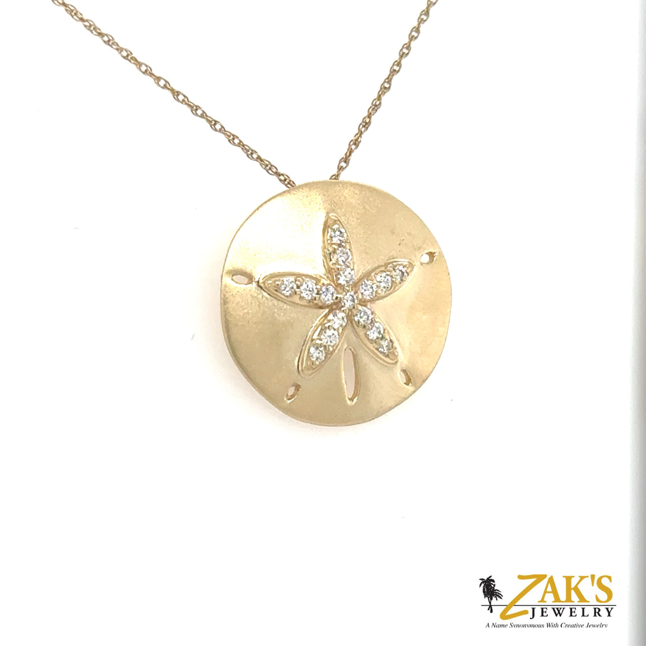 14K yellow gold sand dollar pendant with diamond-accented star motif and brushed finish.