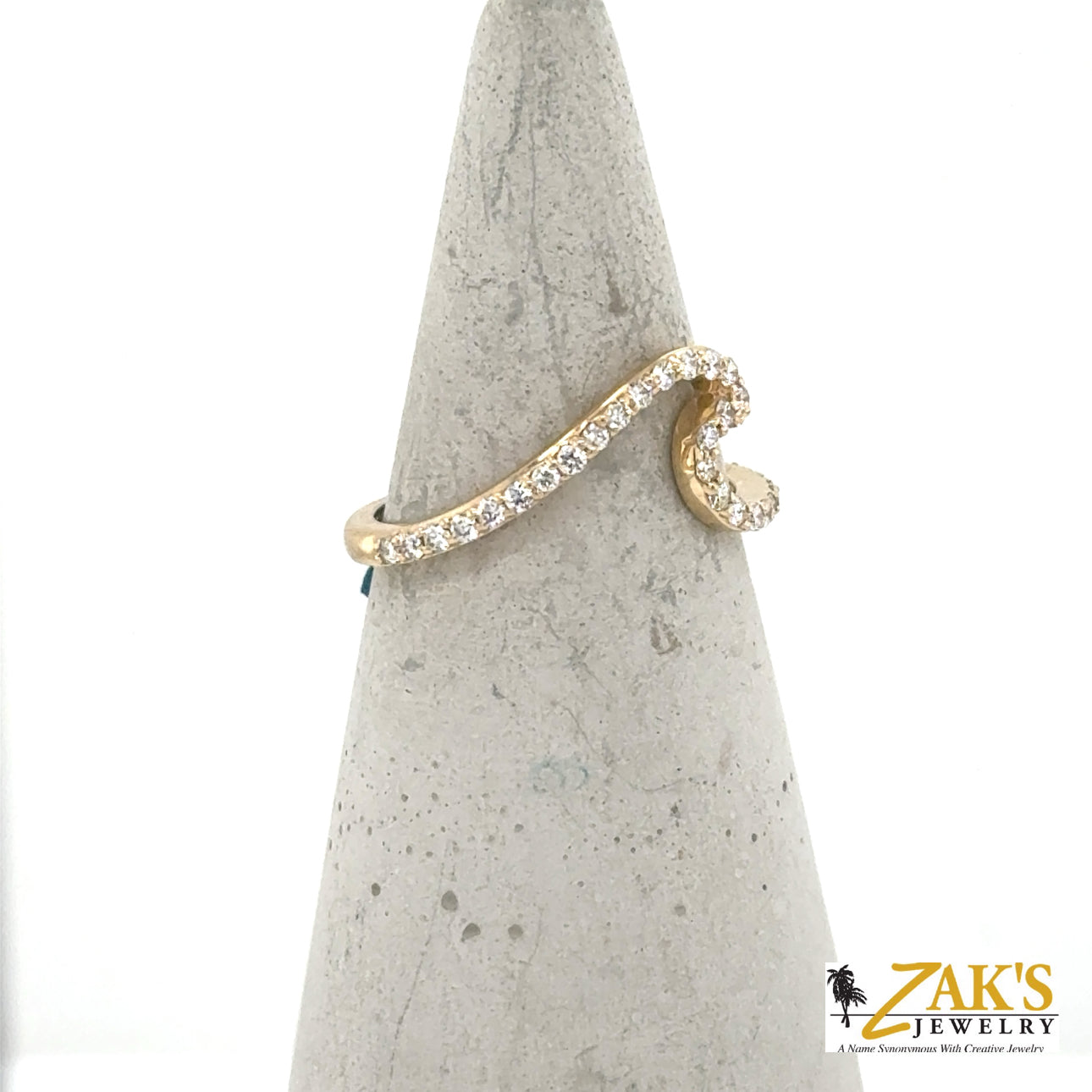 14K yellow gold wave ring with shared-prong round diamonds along the curve.