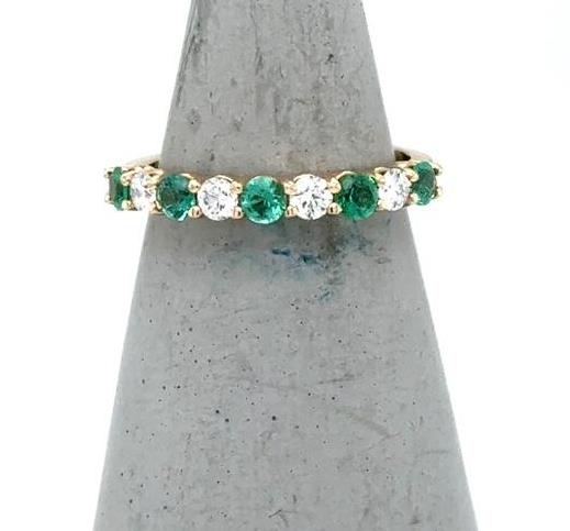 14K yellow gold band with alternating round emeralds and diamonds in shared prongs.