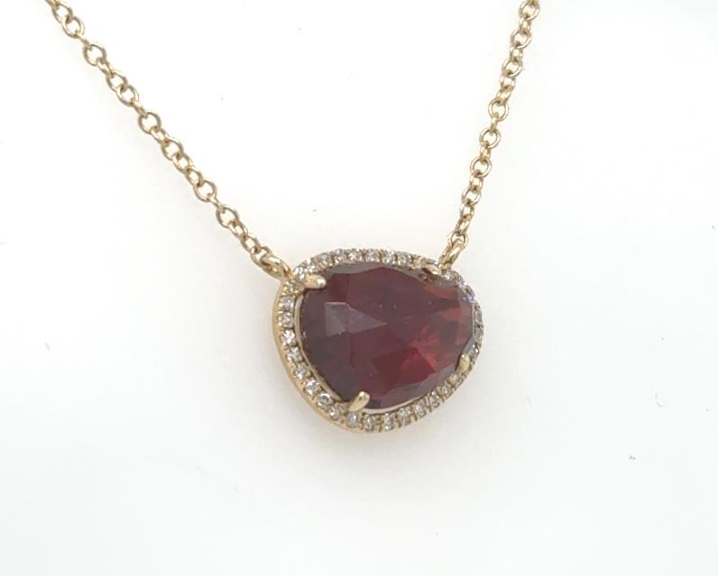 14K yellow gold necklace with fancy-cut garnet haloed by small diamonds.