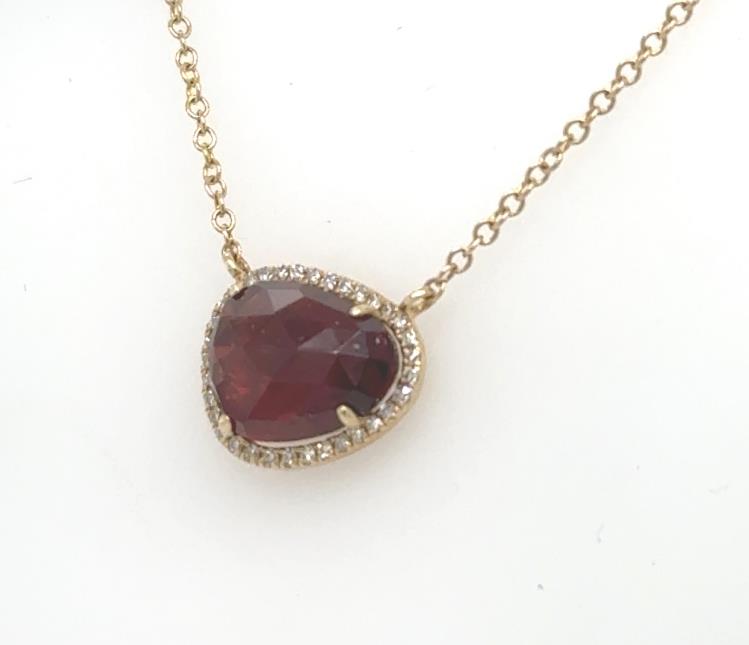 14K yellow gold necklace with faceted garnet pendant and diamond halo on cable chain.