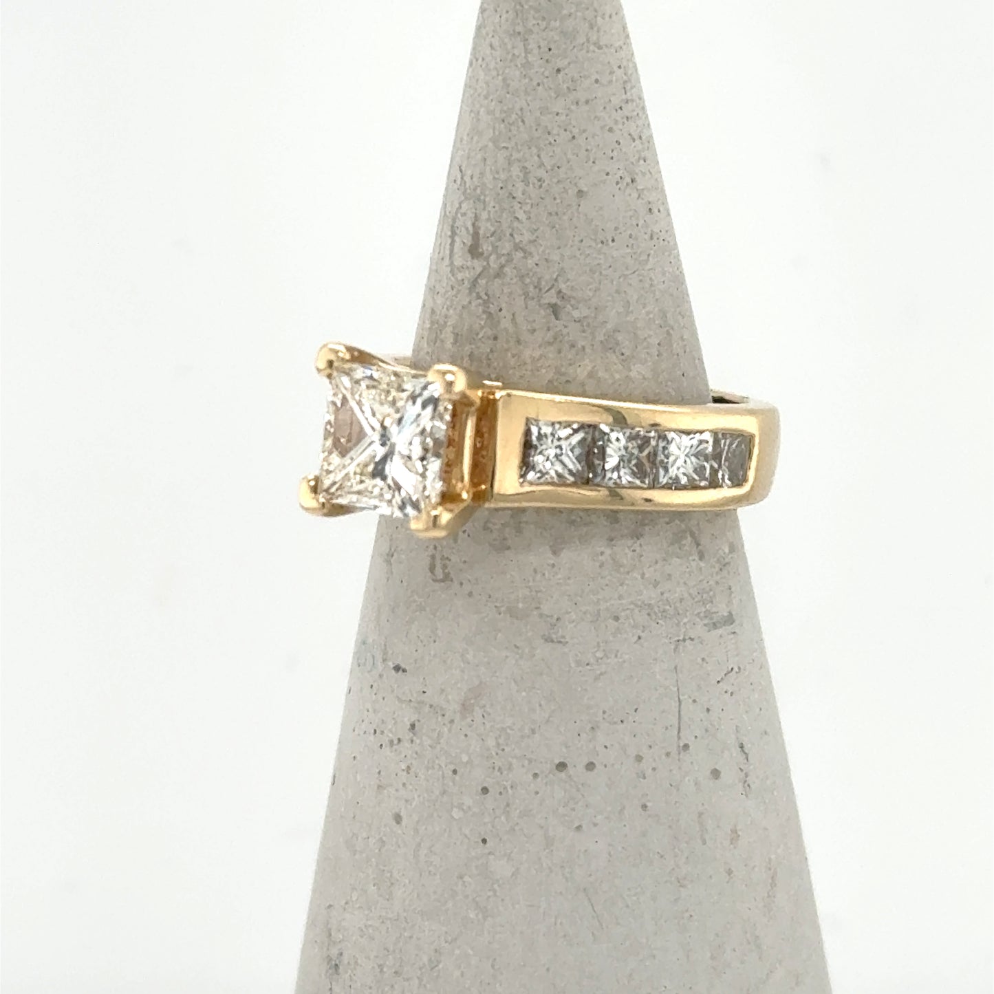 14K yellow gold ring with princess-cut center diamond and channel-set side stones.