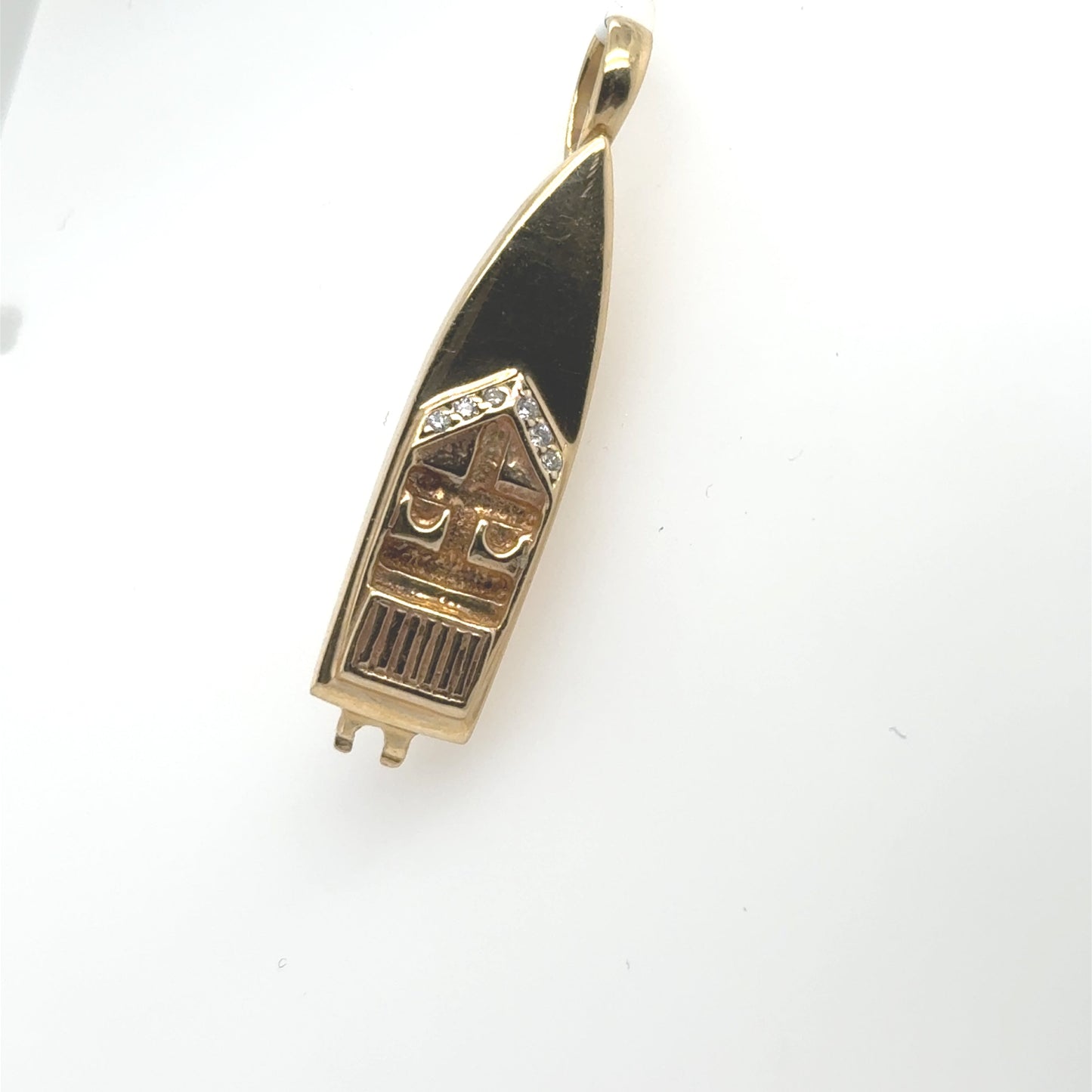 14K yellow gold speedboat pendant with black enamel details and diamond accents.
