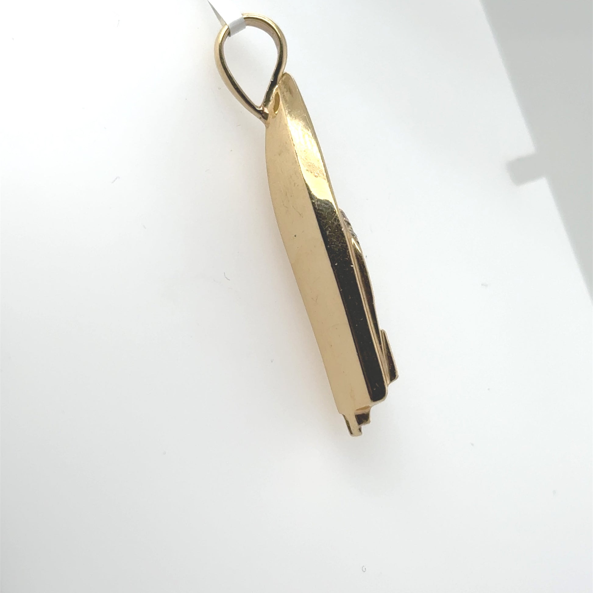 Side view of a polished 14K yellow gold boat pendant with bail.