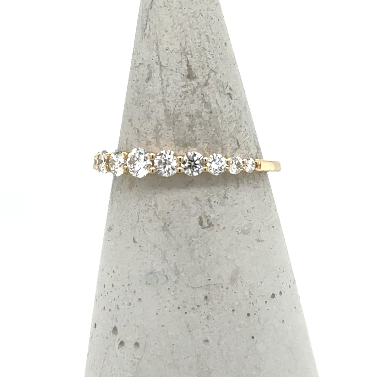 14K yellow gold band with graduated round diamonds in shared-prong setting.