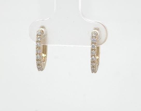 14K yellow gold oval huggie earrings with prong-set round diamonds front-facing.