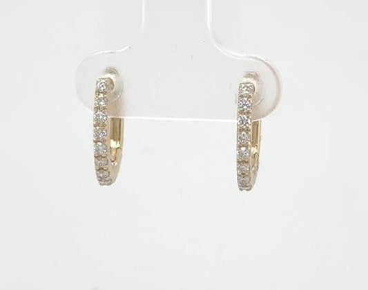 14K yellow gold oval huggie earrings with prong-set round diamonds front-facing.