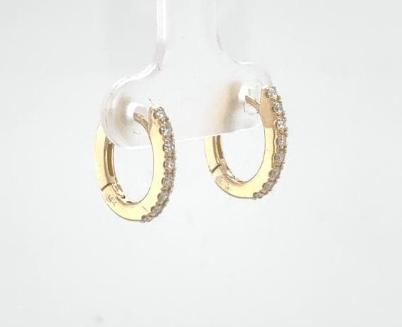 14K yellow gold oval huggie earrings with prong-set round diamond fronts.