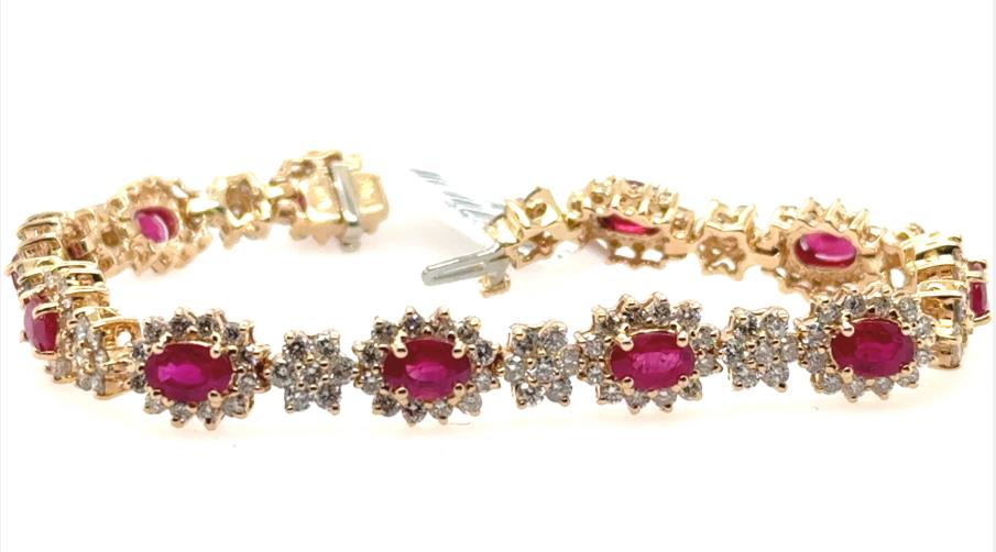 14K yellow gold tennis bracelet with oval rubies and diamond halo links.