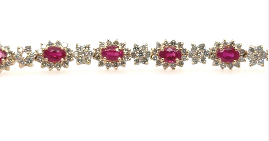 14K yellow gold tennis bracelet with oval rubies and diamond halo links.