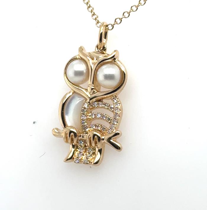 14K yellow gold owl pendant with pearl eyes, mother-of-pearl and diamond accents.