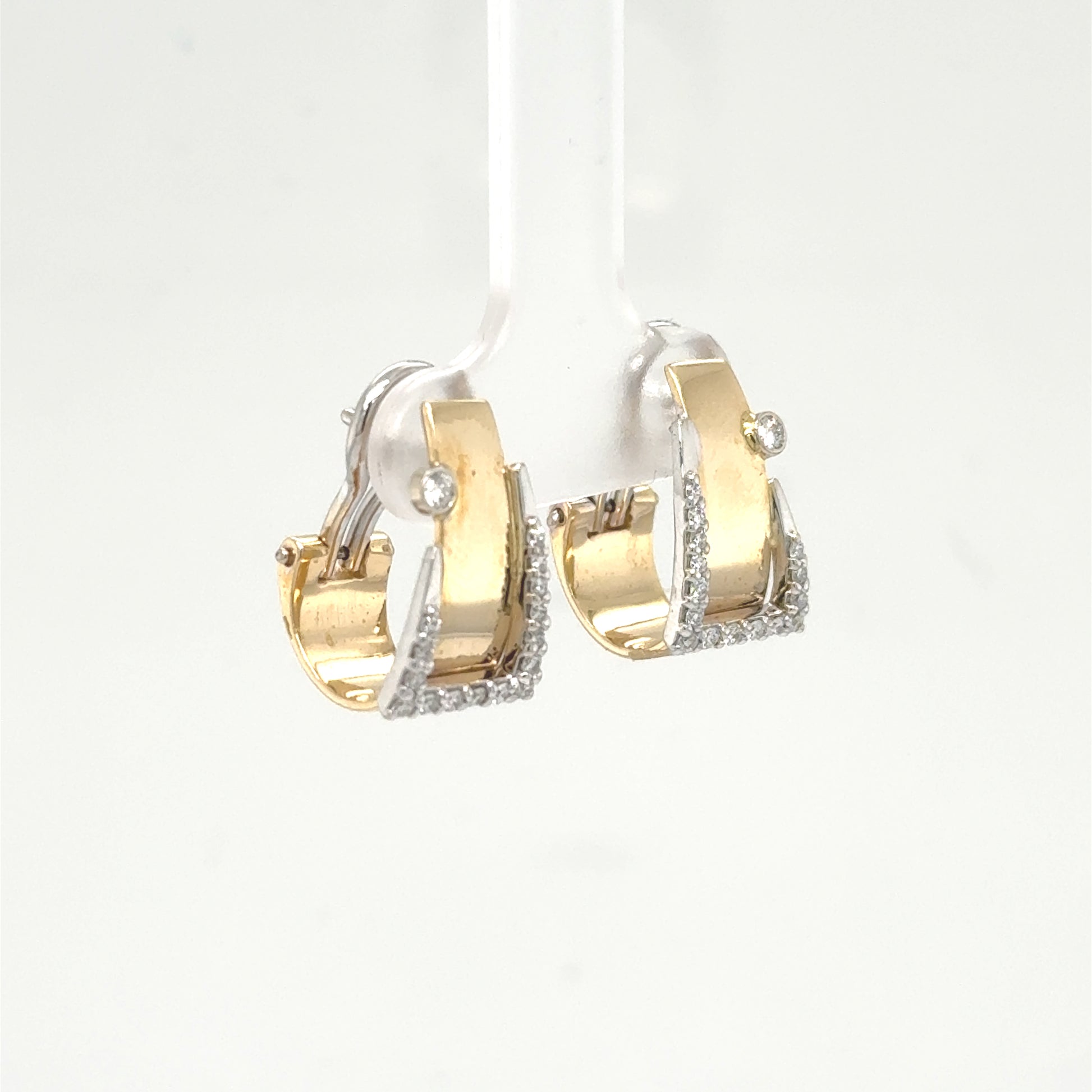 Yellow and white gold buckle hoop earrings with pavé edges and bezel diamond accents.