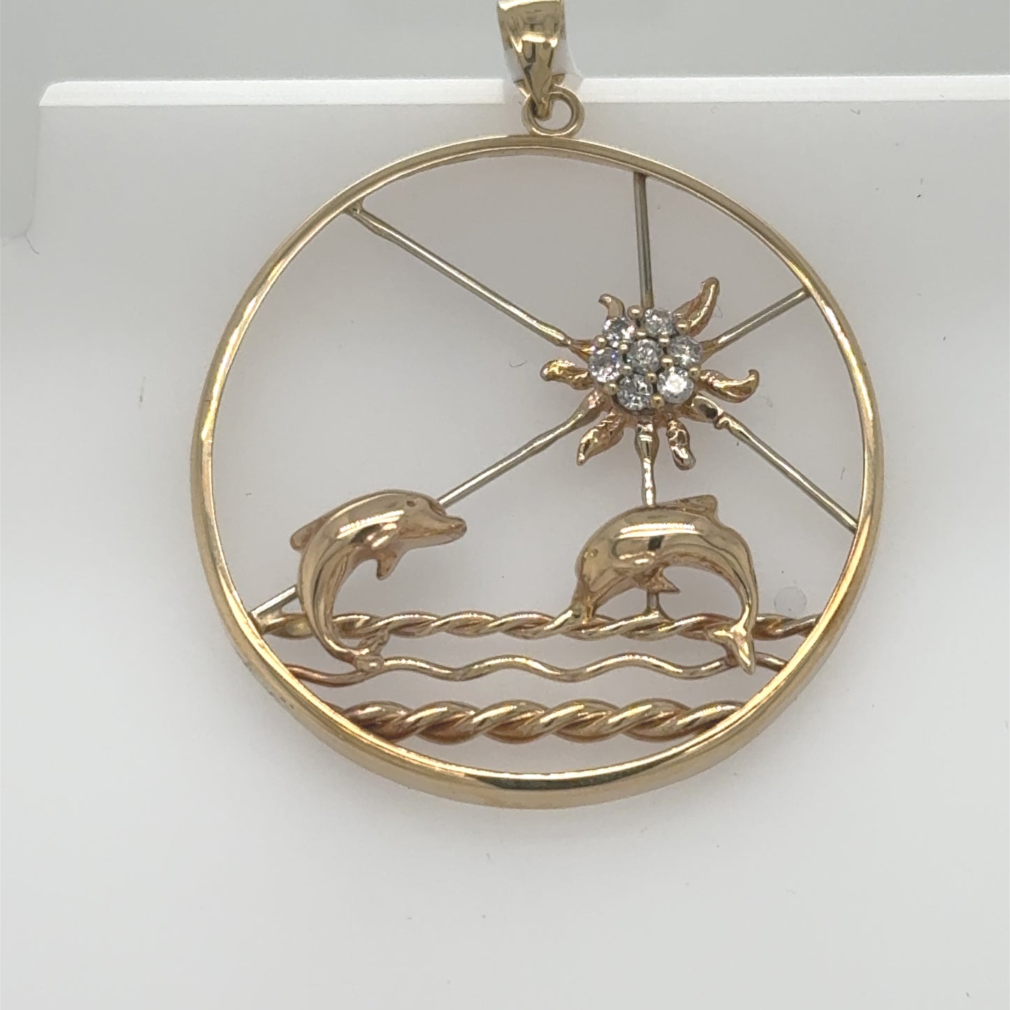 Round 14K yellow and white gold pendant with dolphins and diamond sun.