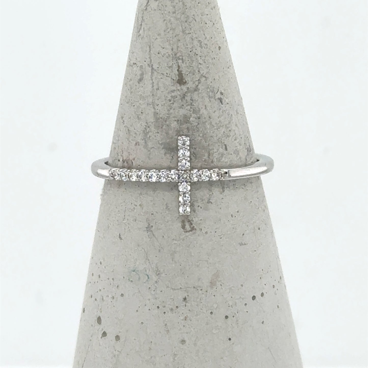14K white gold ring with a sideways diamond cross on a thin band.