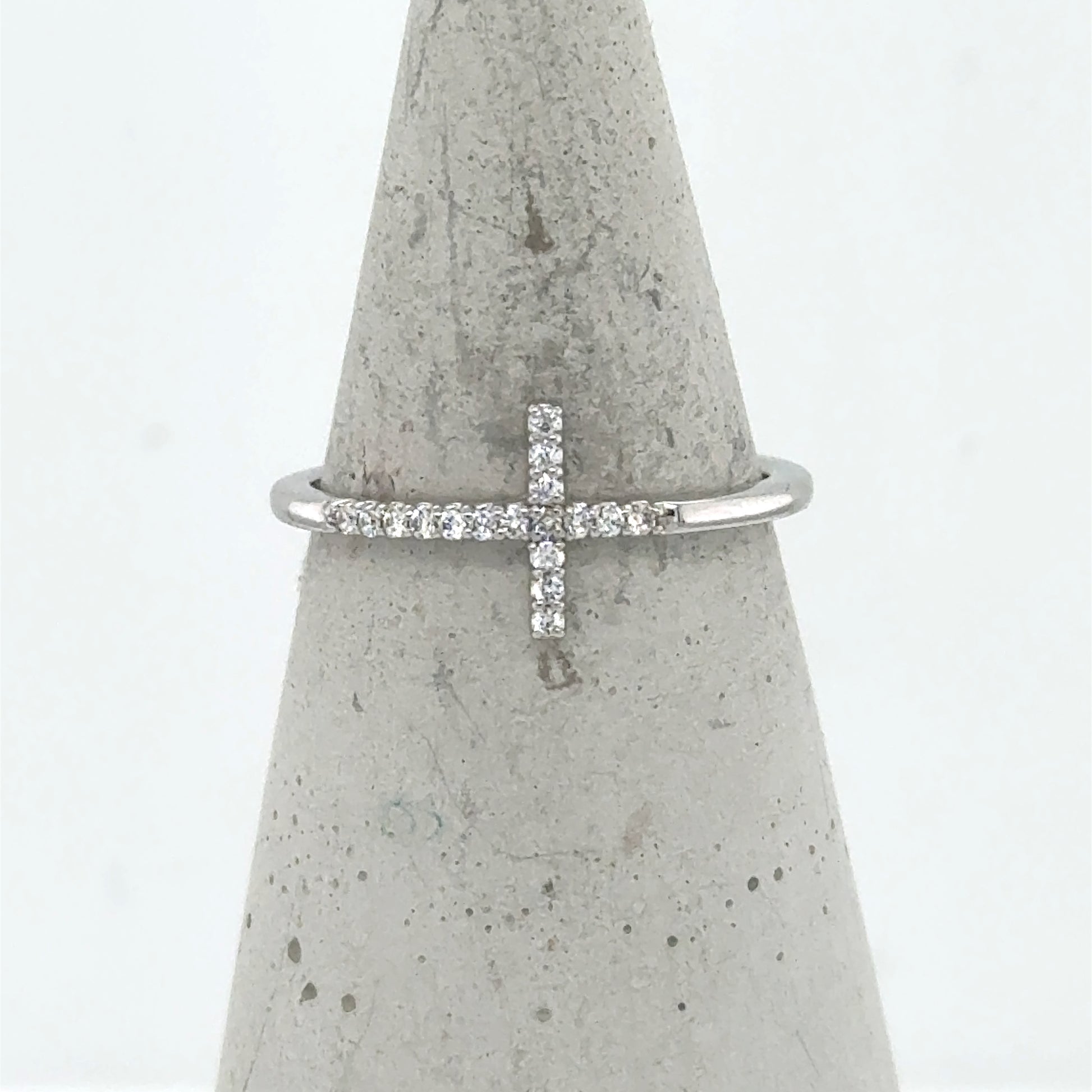 14K white gold ring with a sideways diamond cross on a thin band.