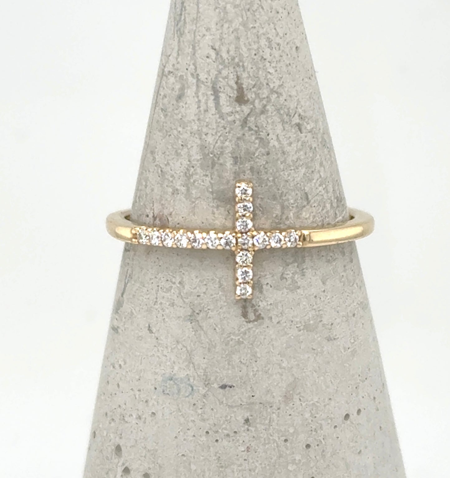Yellow gold ring with a sideways pavé diamond cross on a thin band.