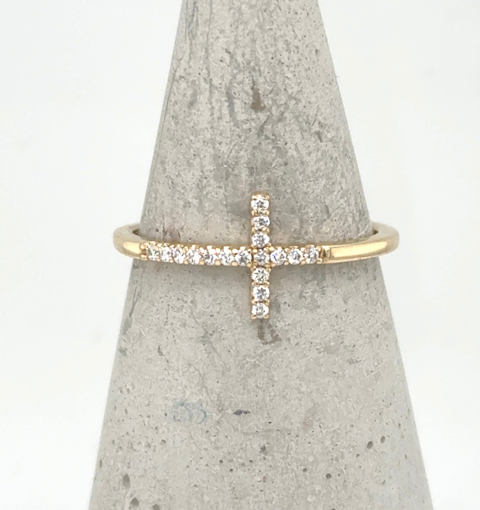 Yellow gold ring with a sideways pavé diamond cross on a thin band.