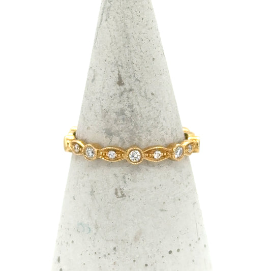 18K yellow gold stackable band with bezel-set round diamonds and milgrain detailing.