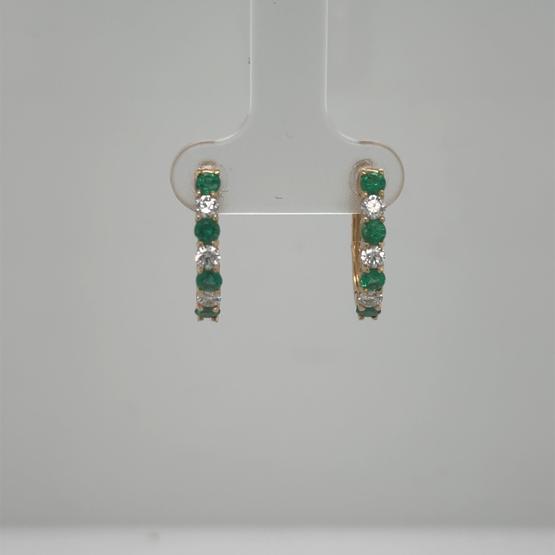 14K yellow gold hoop earrings with alternating round emeralds and diamonds.