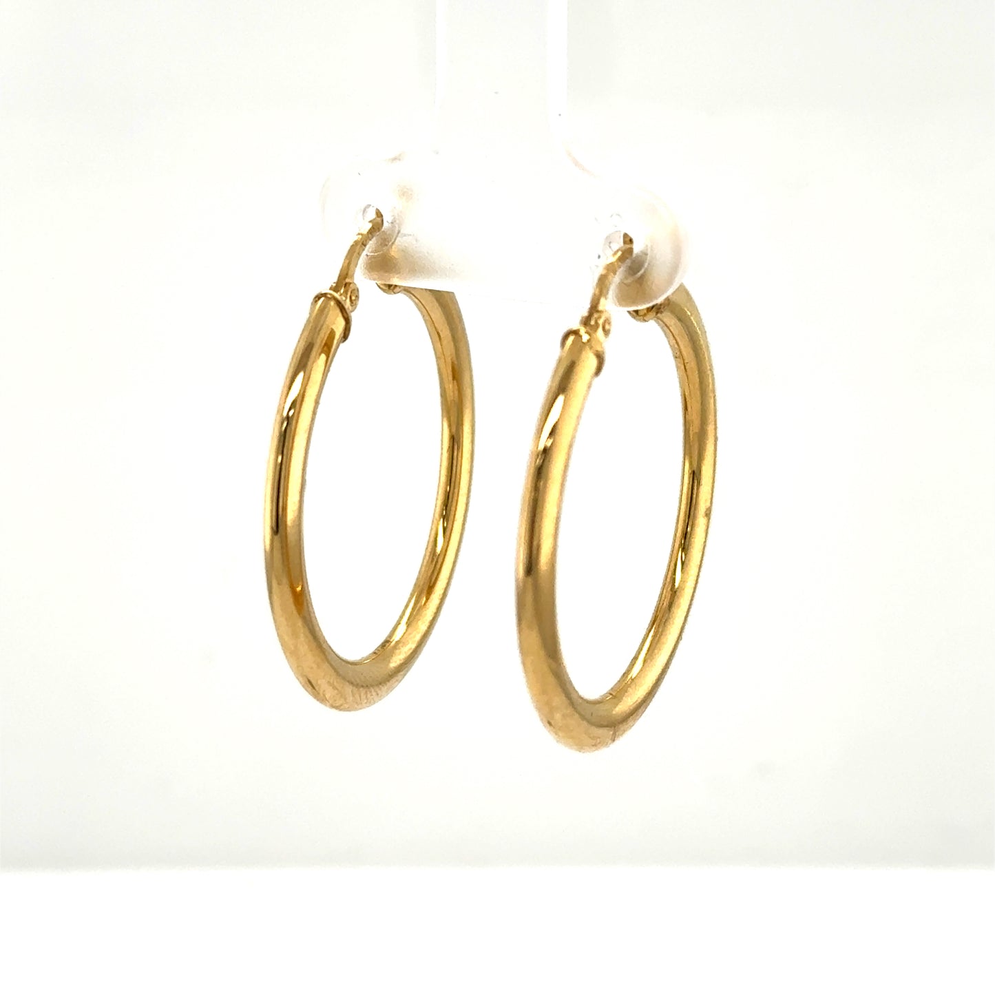 Pair of medium yellow gold tube hoop earrings with hinged closures.