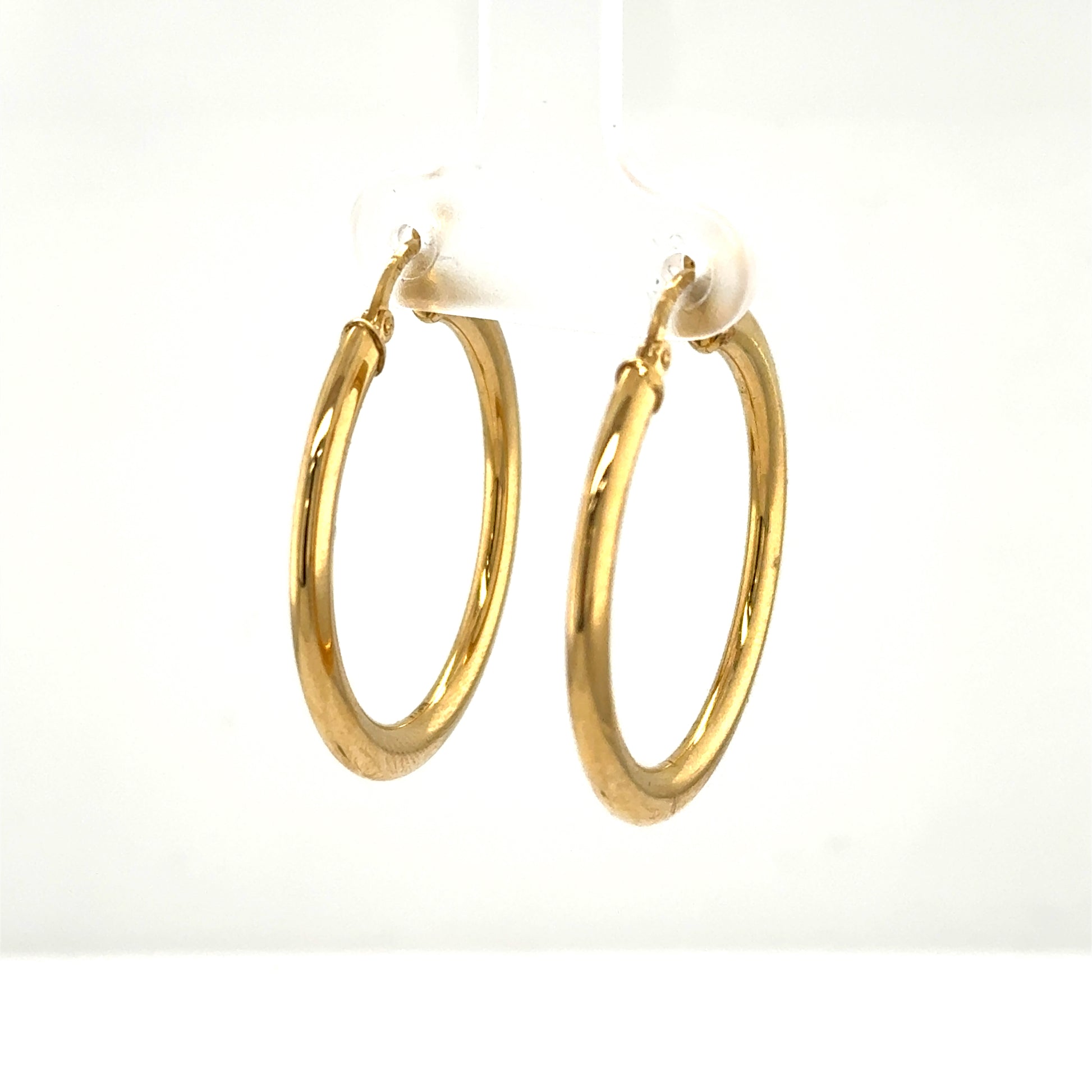 Pair of medium yellow gold tube hoop earrings with hinged closures.