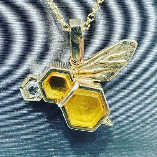 14K yellow gold bee pendant with hexagon amber panels and bezel-set diamond.