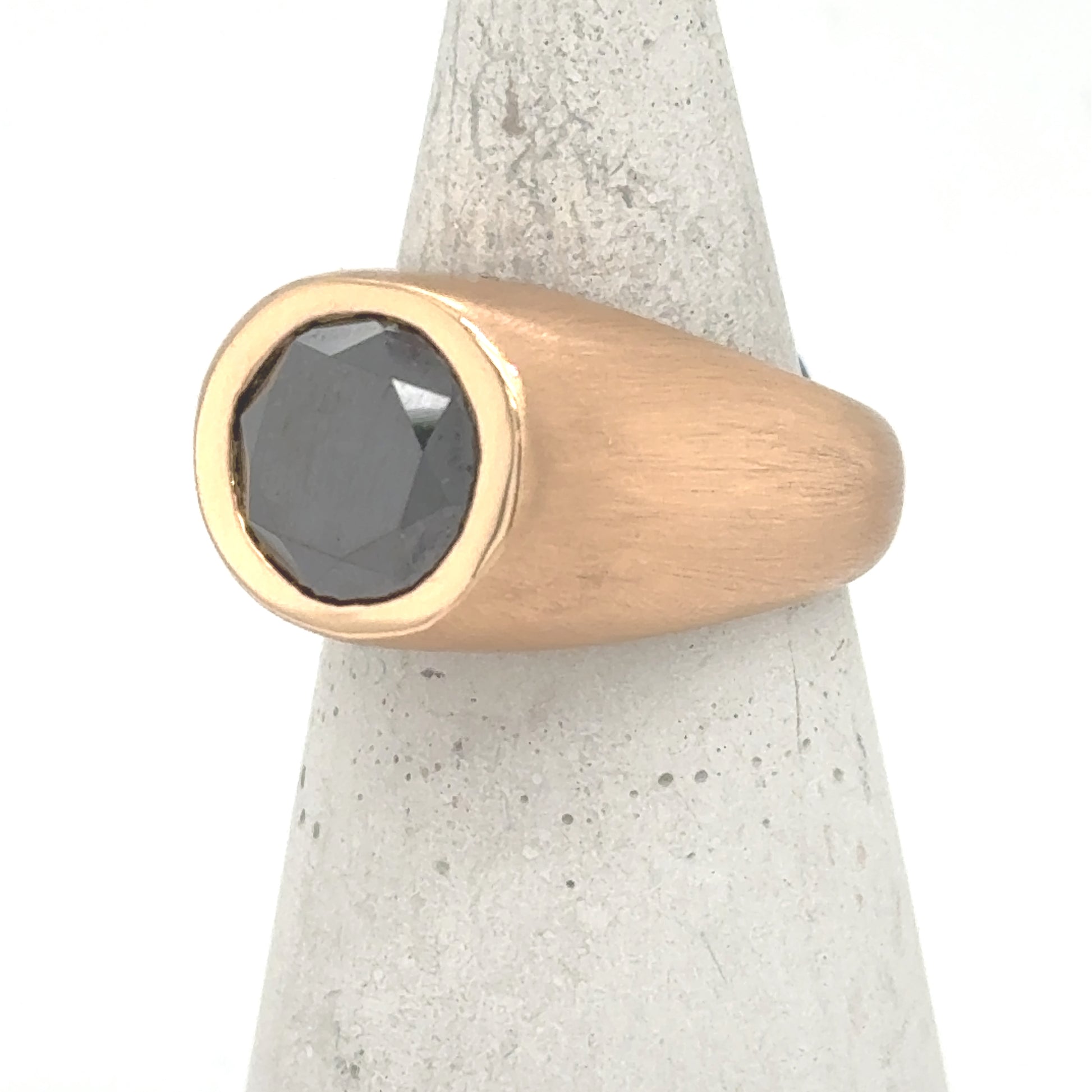 18K rose gold ring with bezel-set round black diamond and tapered band.