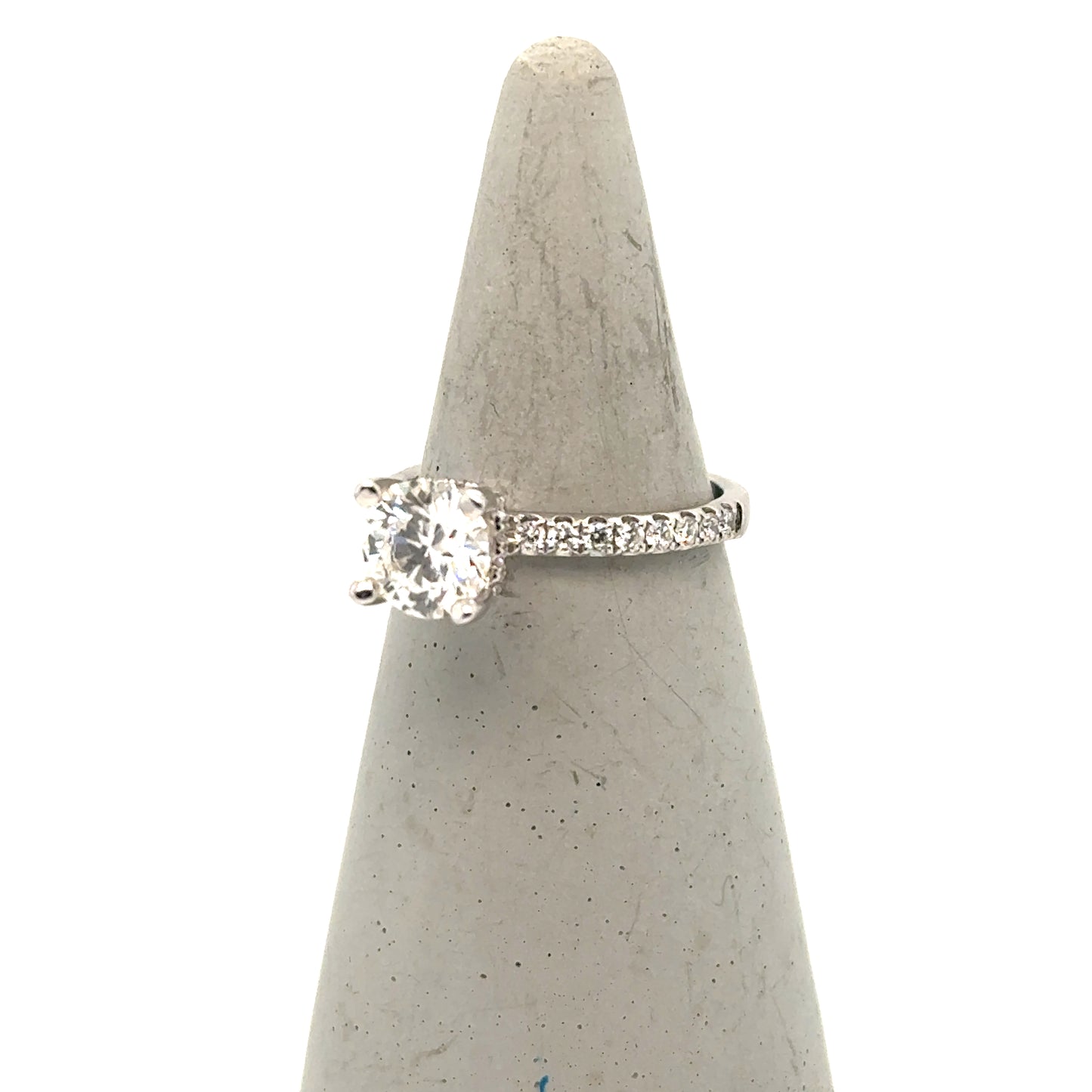 White gold engagement ring with round solitaire diamond and pavé diamond band.