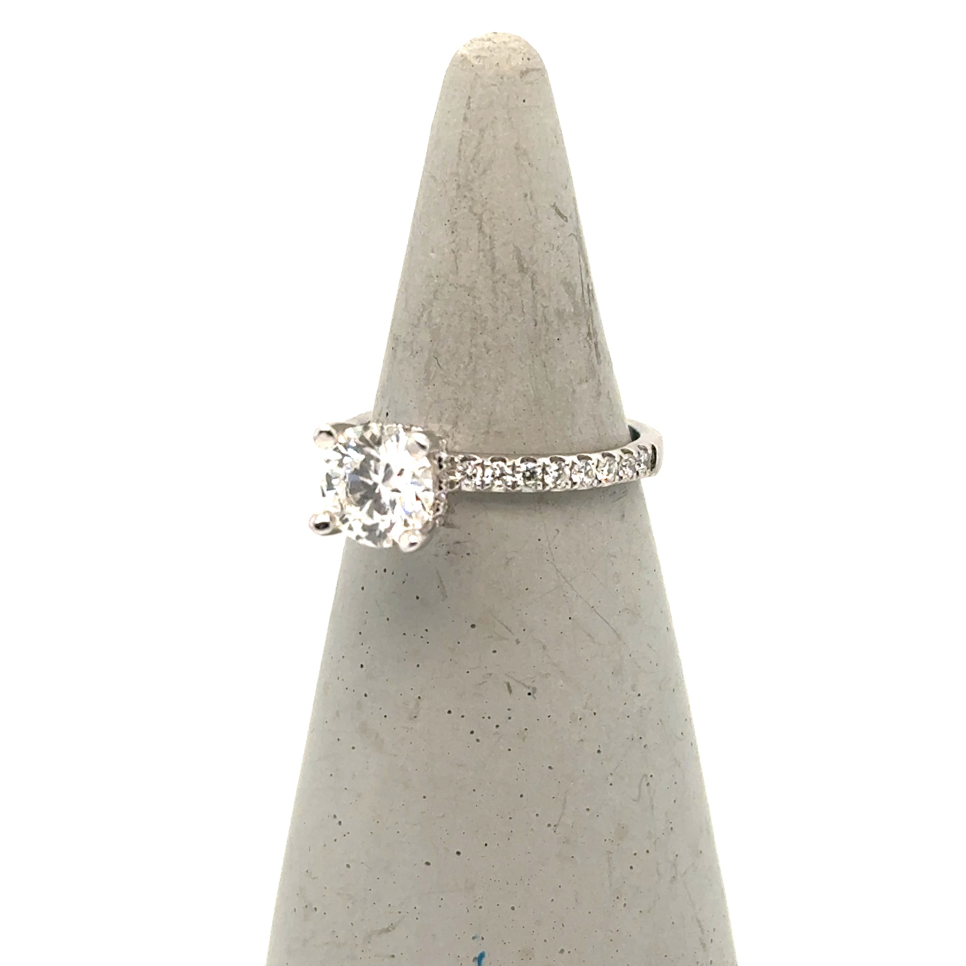 White gold engagement ring with round solitaire diamond and pavé diamond band.