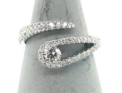 18K white gold bypass ring with pavé band and round center diamond.