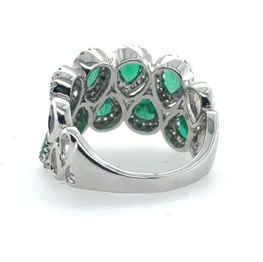 18K white gold band with pear-shaped green emeralds and diamond halos.