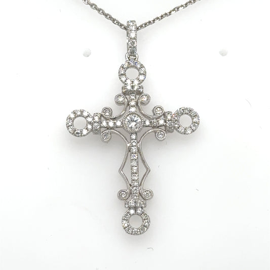 18K white gold cross pendant with round diamonds and ornate scrollwork on chain.