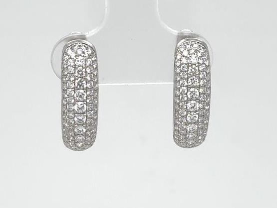 Oval 18K white gold hoop earrings paved with round brilliant diamonds.