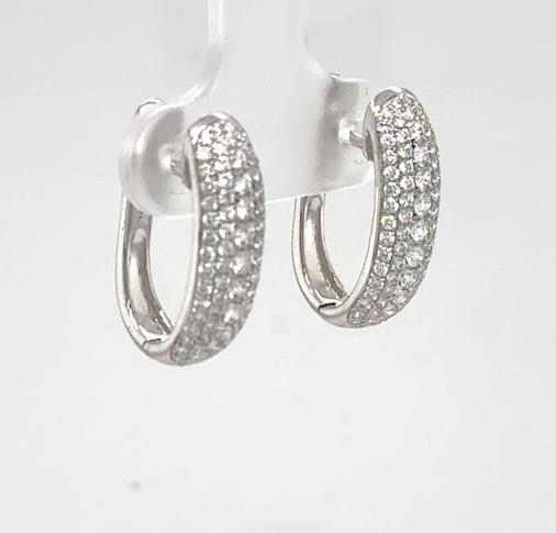 18K white gold oval hoop earrings with pave-set round diamonds throughout.