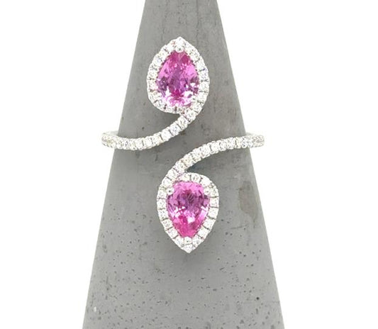 18K white gold bypass ring with two pear-cut pink sapphires and diamond halos.