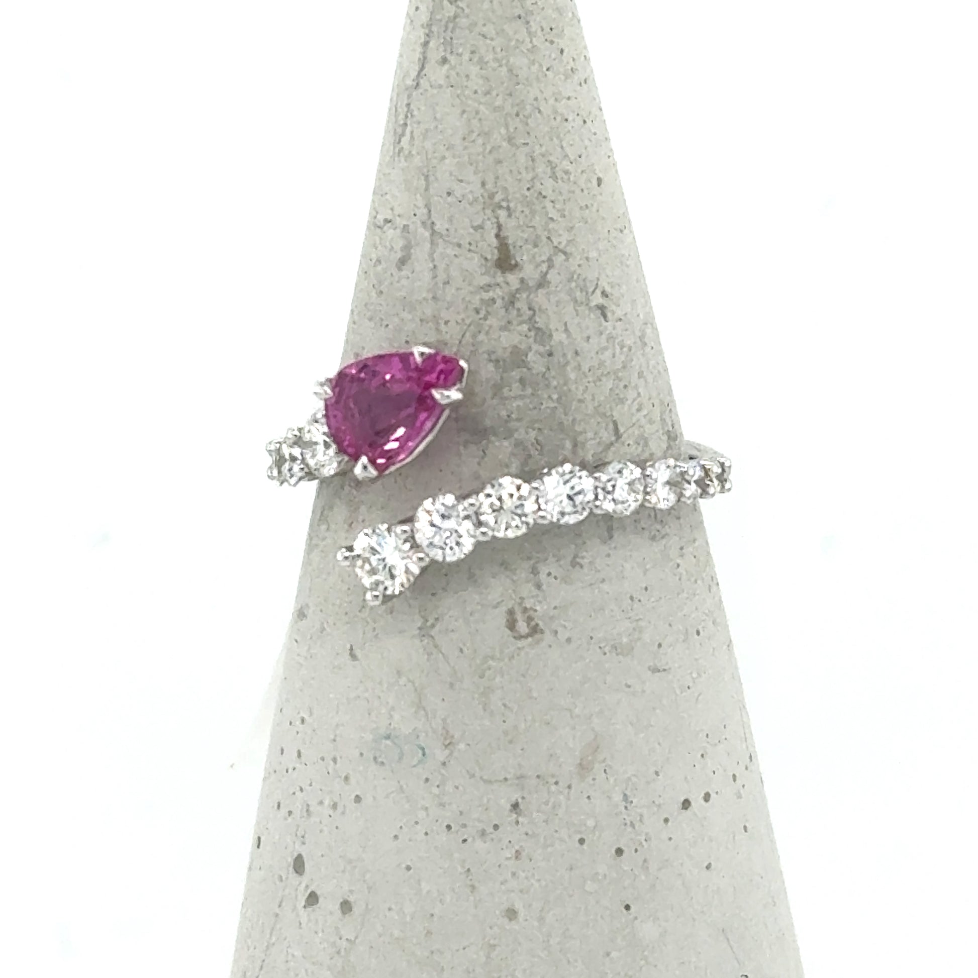 18K white gold bypass ring with pear-cut pink sapphire and round diamonds.