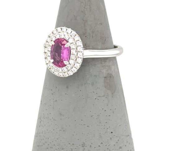 Oval pink sapphire halo ring in white gold with double diamond surround.