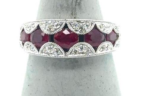 White gold band with five oval red rubies and scalloped diamond accents.