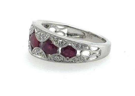 18K white gold band with five oval rubies and round diamond accents.