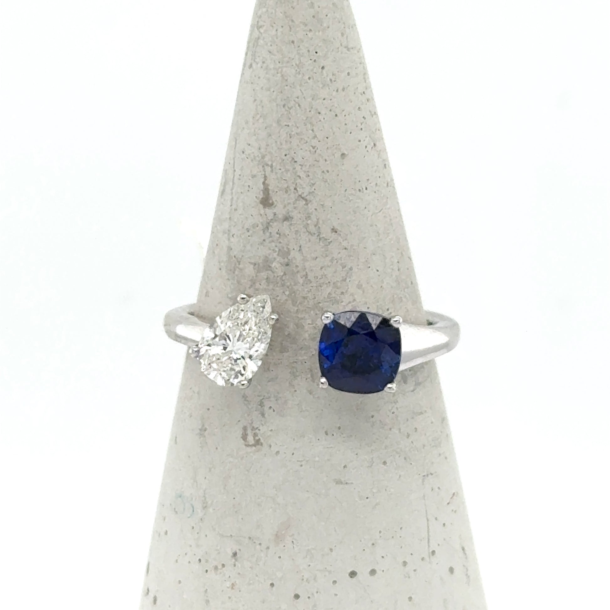 18K white gold Toi et Moi ring with pear diamond and cushion blue sapphire.