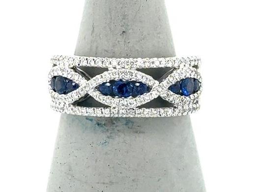 White gold band with infinity motif, blue sapphires channel-set, diamond pavé edges.