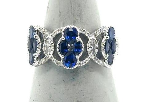 18K white gold ring with oval blue sapphires and diamond-accented loops.