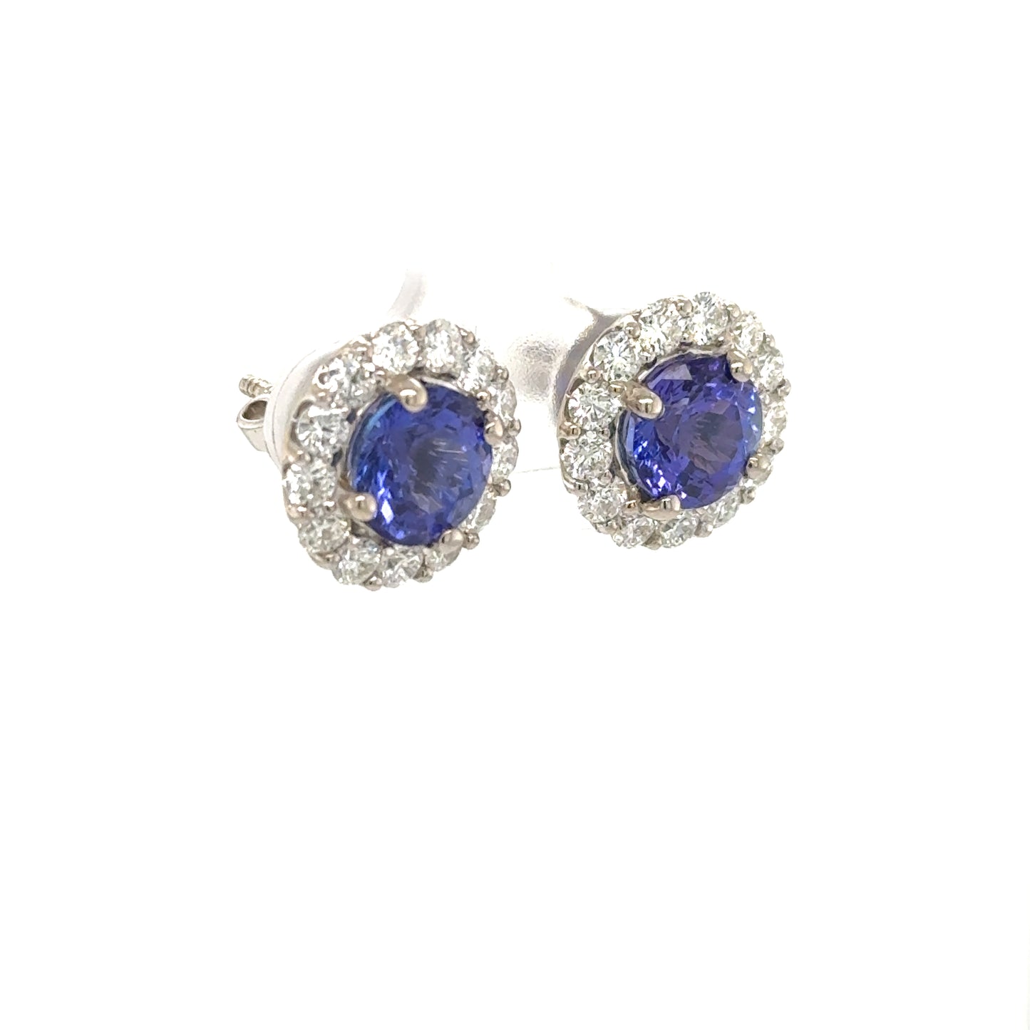 18K white gold stud earrings with round blue tanzanites and diamond halos.