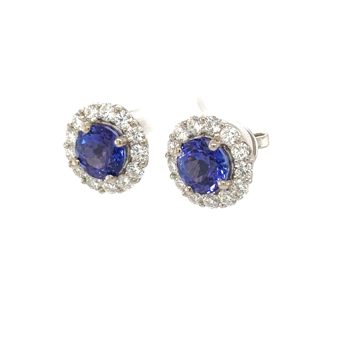 18K white gold stud earrings with round tanzanites and diamond halo settings.