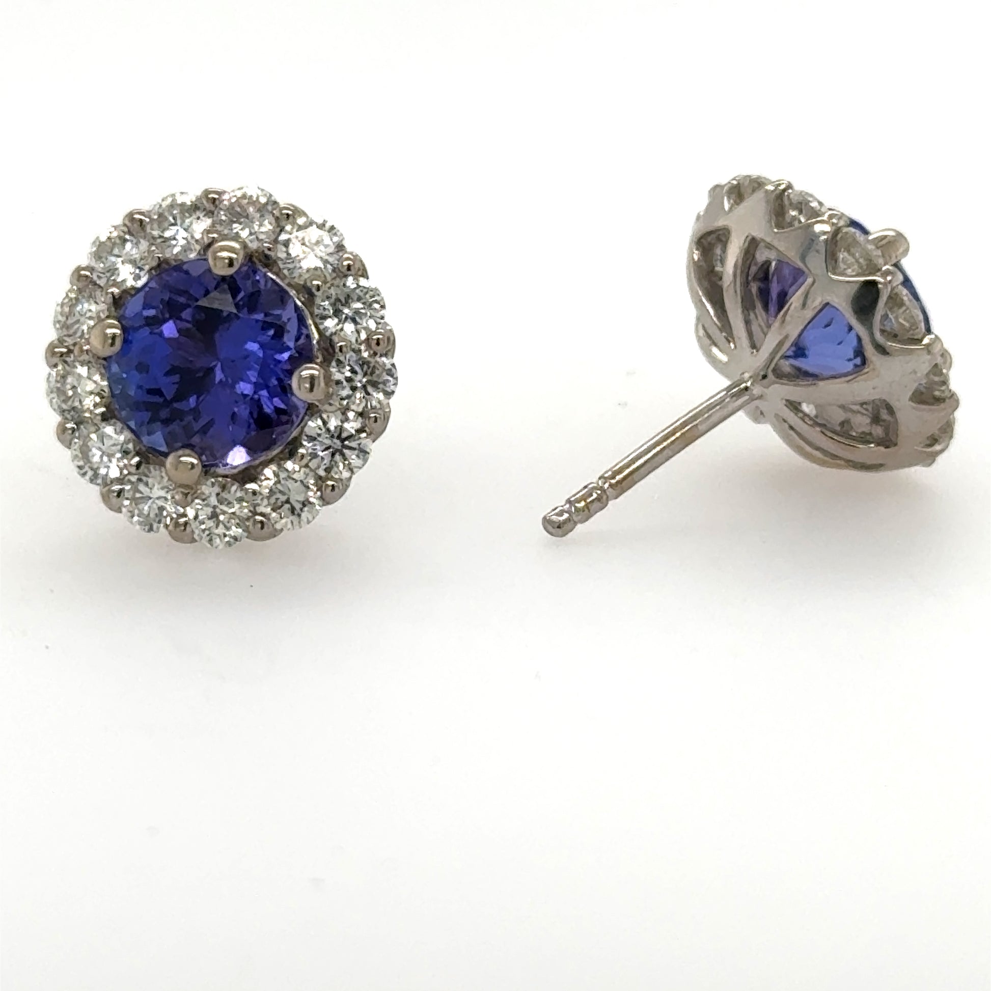 Round tanzanite halo stud earrings in white gold with diamond accents and posts.